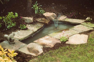 A landscaped garden pond decorated with paving slabs