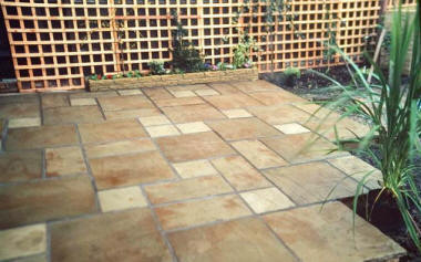 Paved patio with tresil fencing and landscaped garden